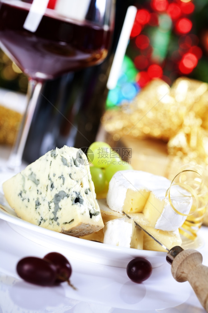 圣诞树背景的奶酪和葡萄酒图片