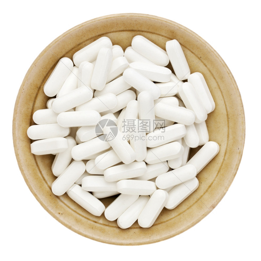 小陶瓷碗中的白维生素补充剂或药丸图片