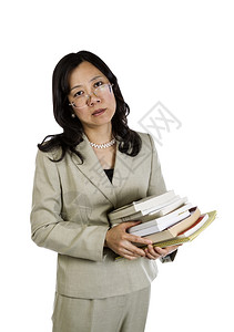 年轻亚洲女在工作过期时持有一堆白色背景的书籍图片