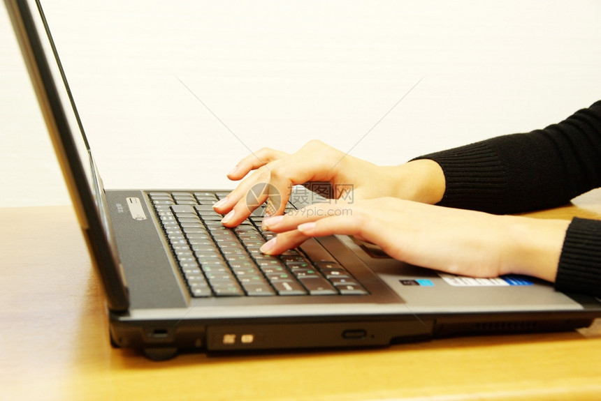 女用手在膝上型电脑键盘打字图片