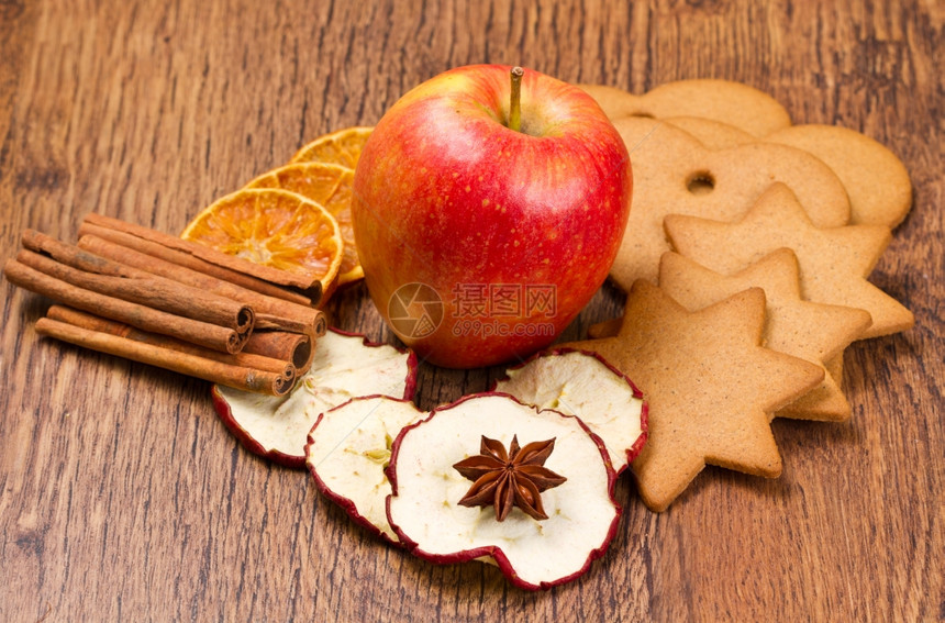 鲜苹果有饼干肉桂和水果木制桌上干图片