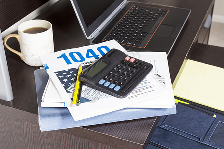纳税服务将纳税申报表与计算机咖啡杯和计算器放在桌上背景