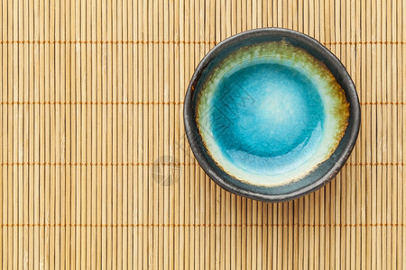 小空陶瓷碗苏司菜盘竹地垫上含蓝食盐图片