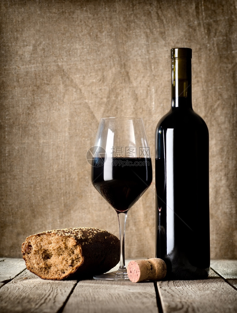 酒和面包在木制桌上图片