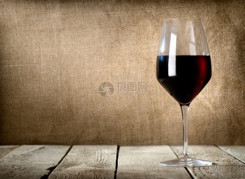 木制桌上的红酒杯图片
