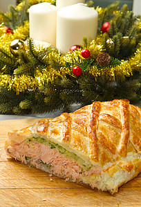 传统鲑鱼在松果糕饼中与菠菜和在圣诞节桌上的苏奇尼混杂在一起图片