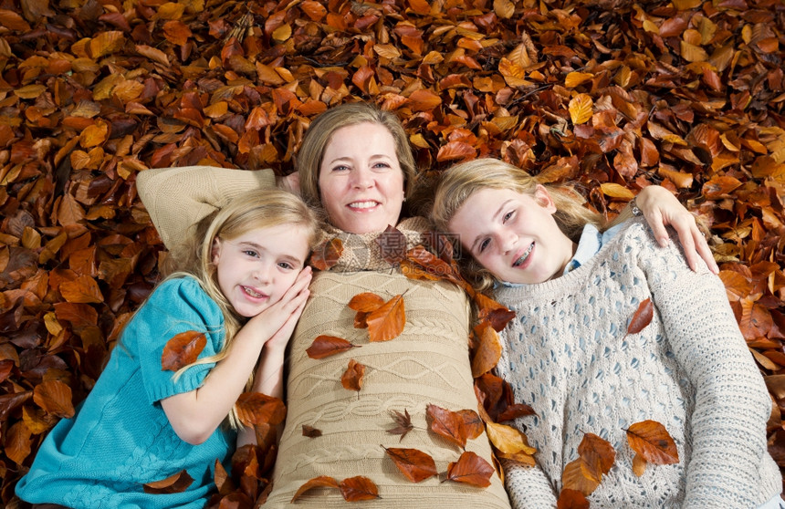 母亲和她女儿躺在秋叶床上图片