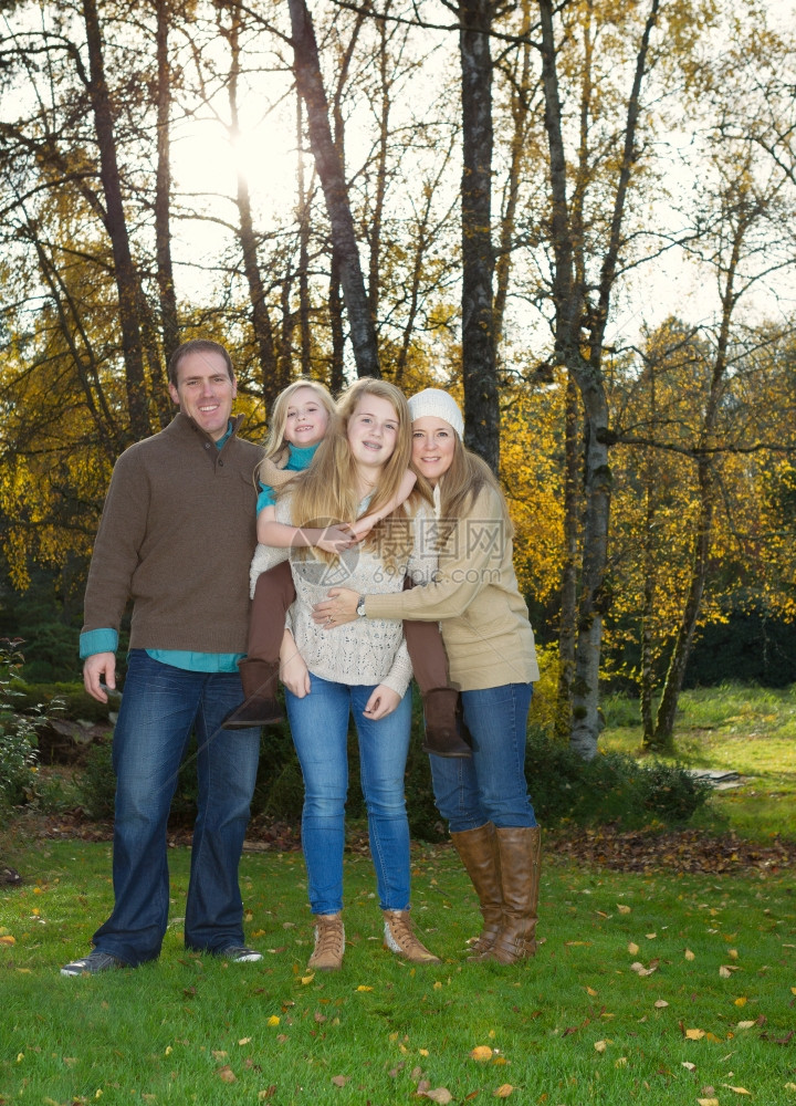 在秋季的好天气家庭站在树前的垂直照片阳光亮图片