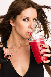 迷人的运动女展示快乐的控股新鲜混合食品水果吸剂饮料图片