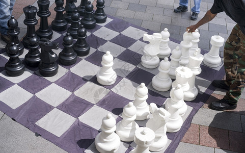 一个男人在街上下棋游戏中移动他的巨人毕晓普主教图片