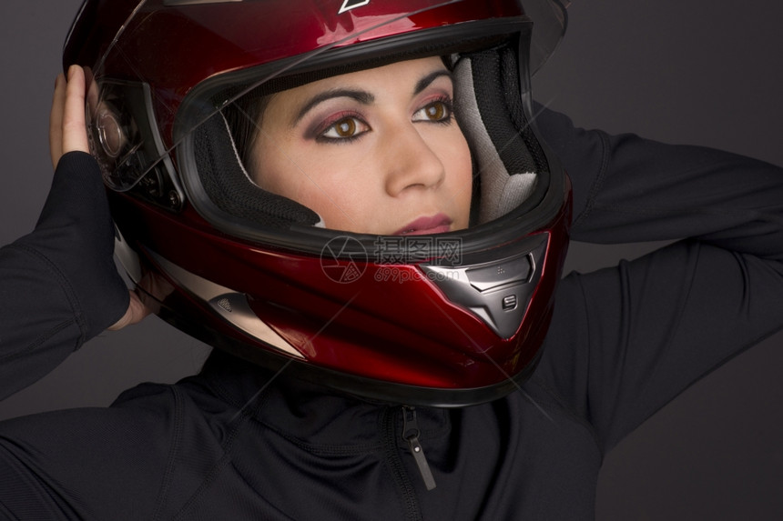 一名女骑手戴上红色全面头盔图片