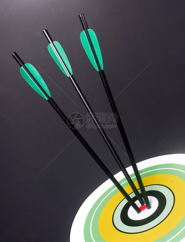 三支绿箭和黑击中圆形多彩目标红心中图片