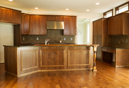 新住宅厨房的横向照片上面有石柜樱桃和硬木地板图片