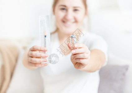 手持胰岛素注射器的微笑妇女图片