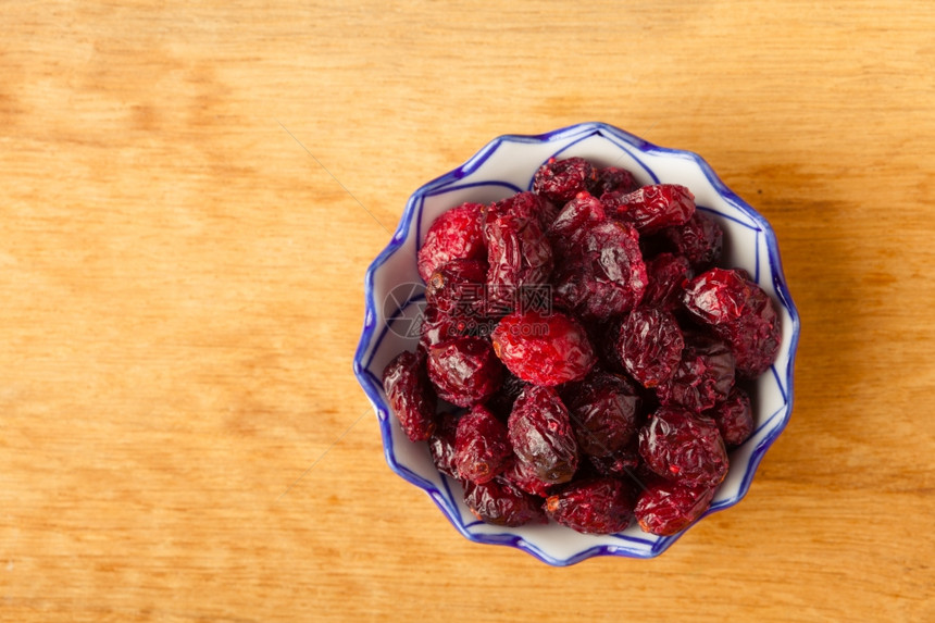 健康的食品有机营养干红莓水果在木桌背景的碗里图片