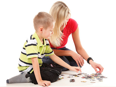 母亲和她儿子一起在地上玩拼谜游戏图片