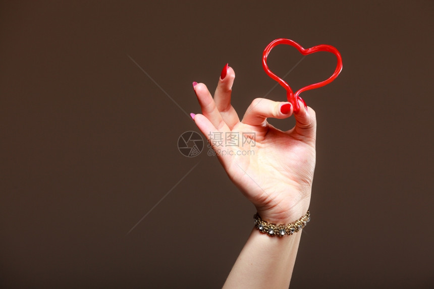 棕色的情人节工作室拍到的女人手握着情红心爱的符号图片