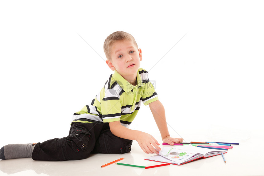 小男孩用彩色铅笔在地板上画图片