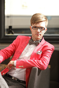 身穿明亮红色夹克和首领带的眼镜英俊时装男模特图片