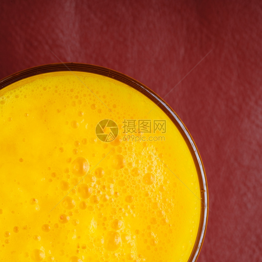 关闭红底的新鲜夏季饮料黄果汁图片