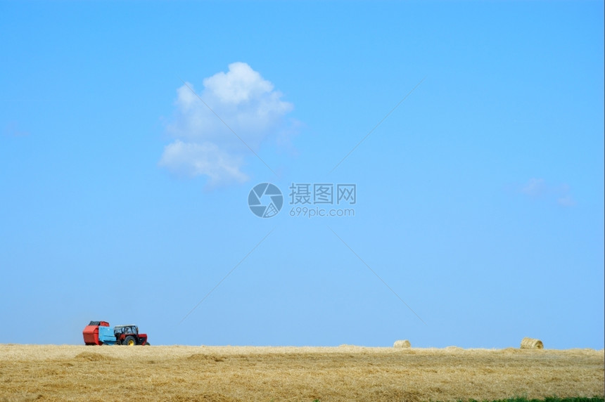拖拉机在田里工作蓝天图片
