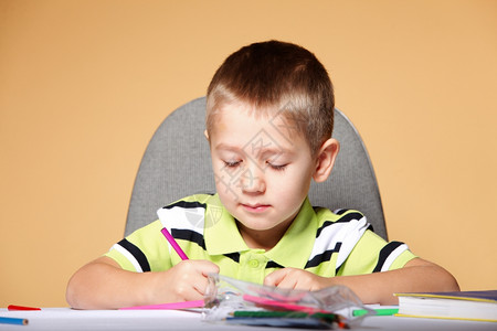 小男孩用彩色铅笔绘画图片