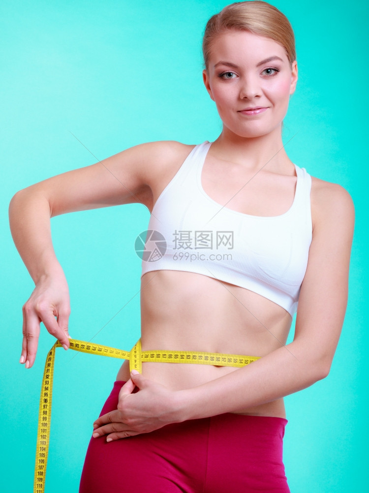 健康照顾和营养年轻身体健康的妇女适合孩用测量胶带她的腰围蓝色绿图片