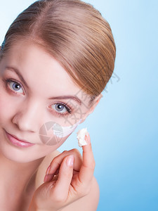 皮肤习惯年轻女表情是蓝色红毛皮的象征女孩用湿润奶油照顾干皮肤美容治疗图片