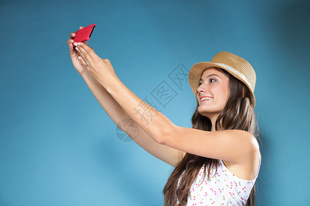 快乐笑的暑期女孩智能手机拍摄自己照片图片