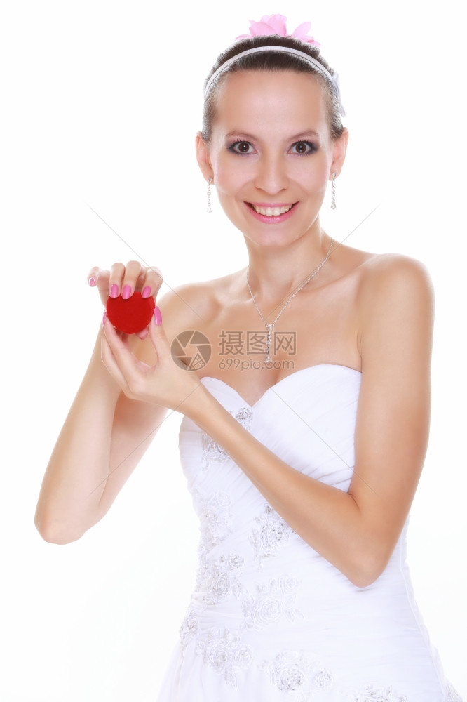 穿着白色礼服的女新娘惊讶地看着红盒子带结婚戒指孤立在白色背景上图片
