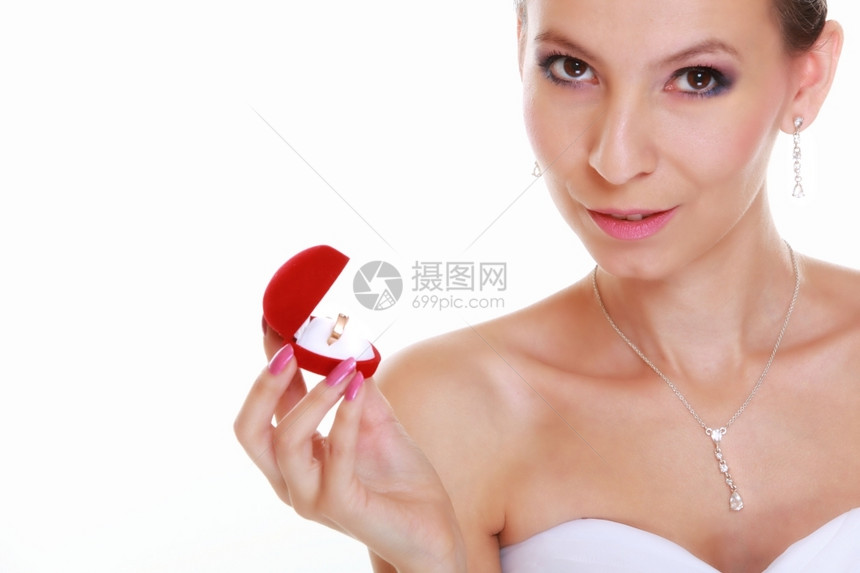 穿着白裙子的女新娘看着红心箱带订婚或结戒指孤立在白色背景上图片