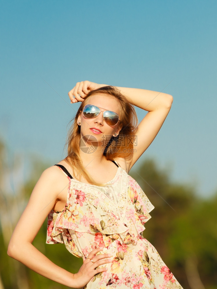 渡假穿暑期礼服的女孩和太阳镜站在空旷的海滩上年轻女人在海边放松夏天图片