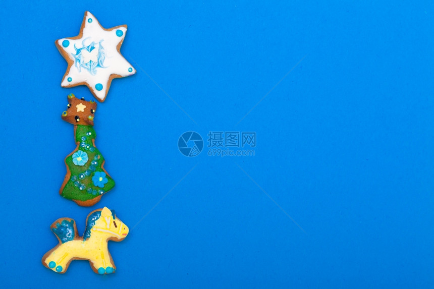 土制的姜饼蛋糕小马圣诞树和星有糖霜彩色装饰蓝作为框架背景假日手工装饰概念图片