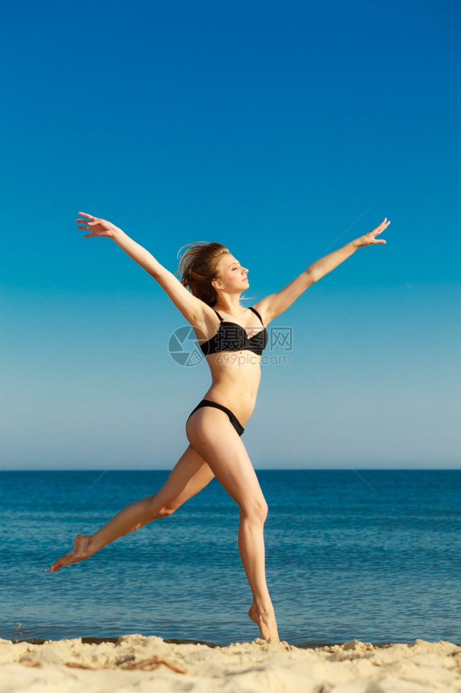 暑假穿比基尼的姑娘在海滩上跑步年轻女人在海边放松愉快夏天图片