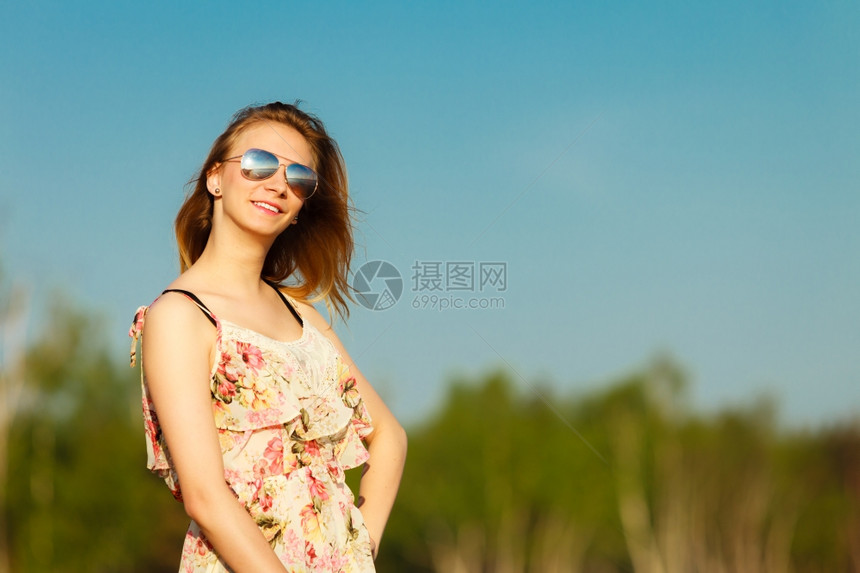 渡假穿暑期礼服的女孩和太阳镜站在空旷的海滩上年轻女人在海边放松夏天图片