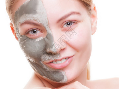 照顾皮肤年轻女脸上戴着粘土面具女孩照顾干燥的情谊孤立斯帕和美容治疗背景图片