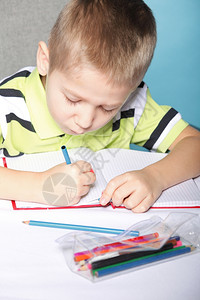 小男孩用彩色铅笔绘画背景图片