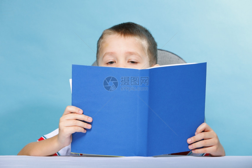 小孩拿着一本公开的书图片