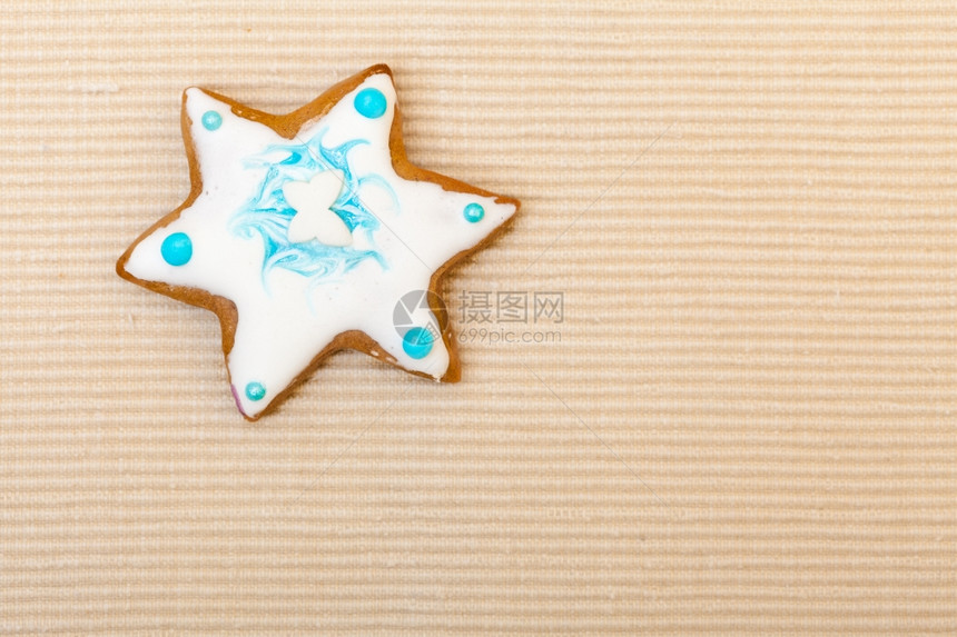 土制姜饼蛋糕明星有糖霜和蓝色装饰在棕作为圣诞节背景图片