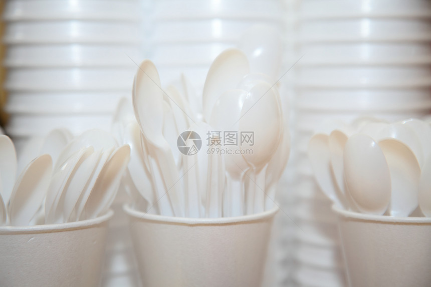可用塑料厨房具堆叠的式碗杯和桌上的勺子图片