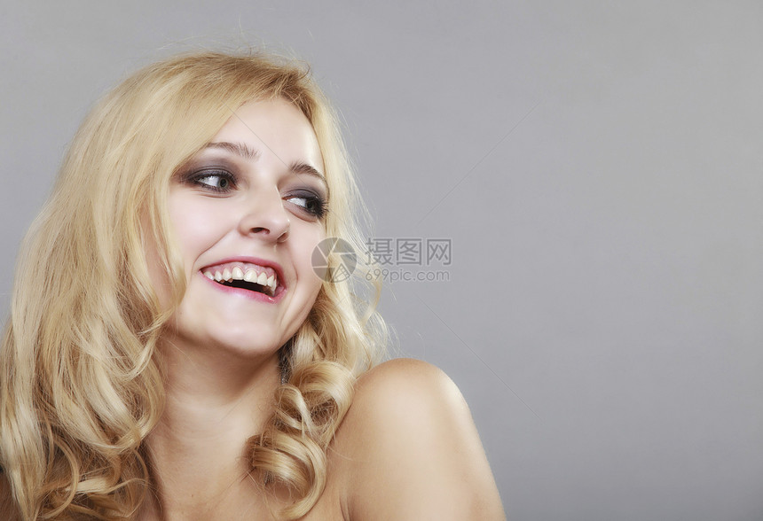 美丽的长发时尚金美女年轻快乐的笑脸女肖像灰色背景的优雅女士图片