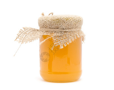 白色背景上的玻璃罐蜂蜜图片