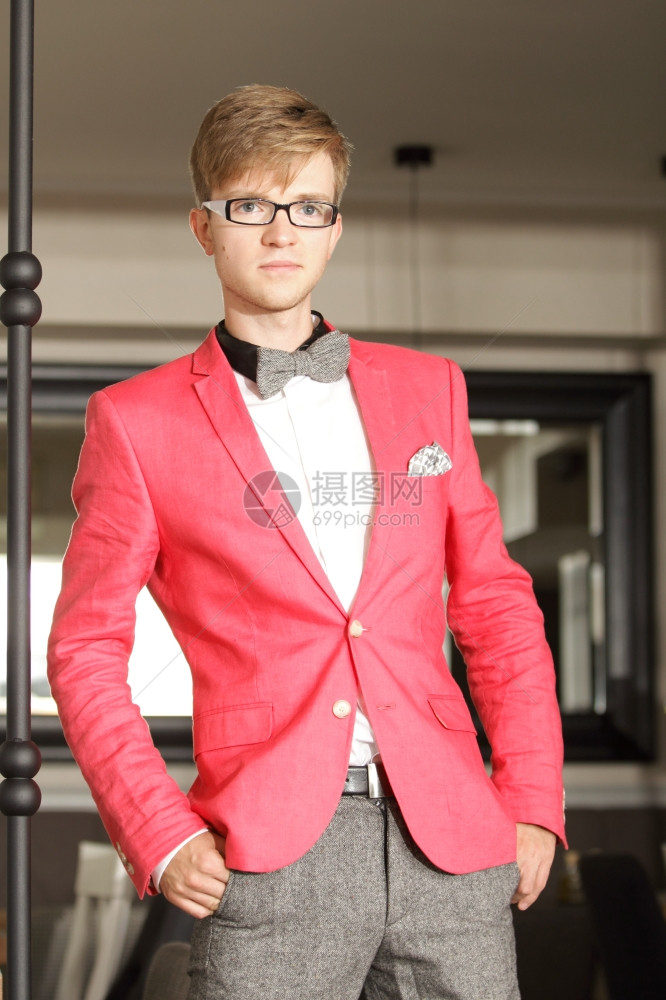 年轻英俊的时装模特穿着明亮的红色夹克身着室内领带图片