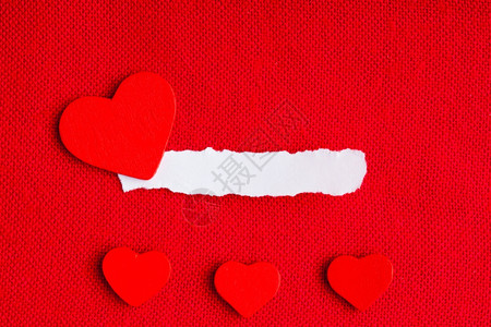 一张白纸的小块空复制间和爱的心符号在红色织物纺材料背景上情人节背景图片