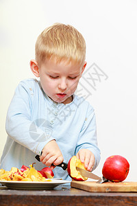 金发男孩用刀子切水果苹童年快乐图片