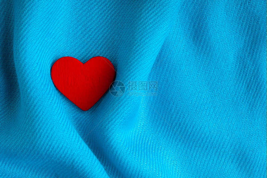 情人节39白天背景红色装饰心脏在抽象的蓝色卷曲折布或纺织品优雅材料上图片