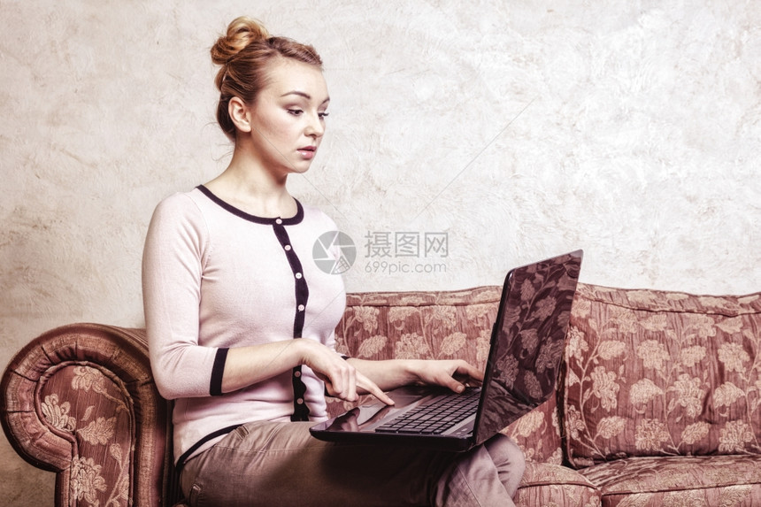 技术互联网现代生活方式概念利用笔记本电脑在回转沙发上工作的年轻商业妇女或学生图片