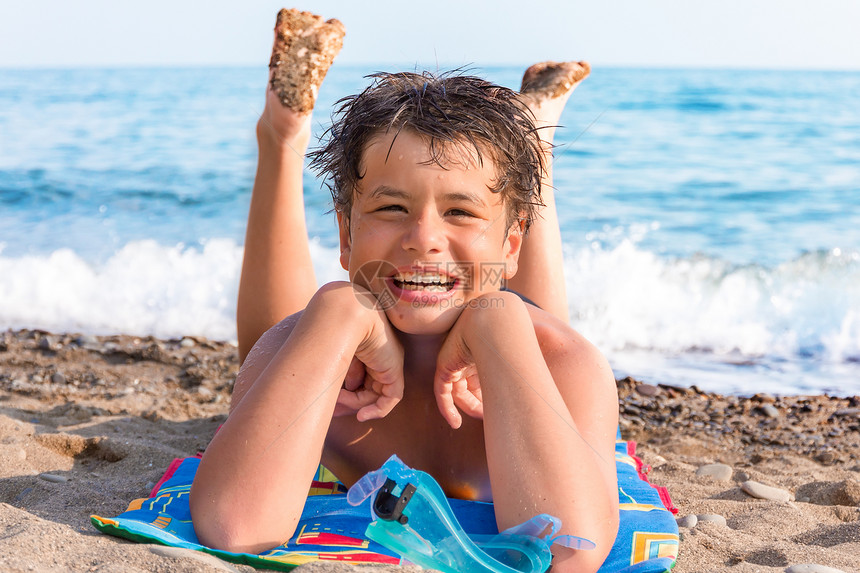 笑的十二岁男孩在海边戴着潜水面具图片