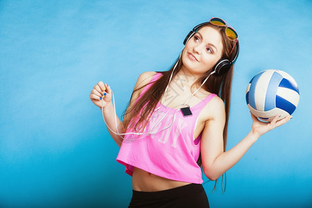蓝色耳机素材时装少女耳机听音乐mp3播放器新鲜的精力充沛年轻女青放松快乐跳着蓝球背景的舞背景