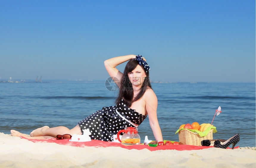 美人坐在沙滩上的红毯子反向风格图片